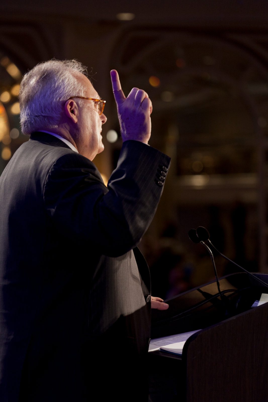 Ed Feulner speaking at a podium with finger pointing up
