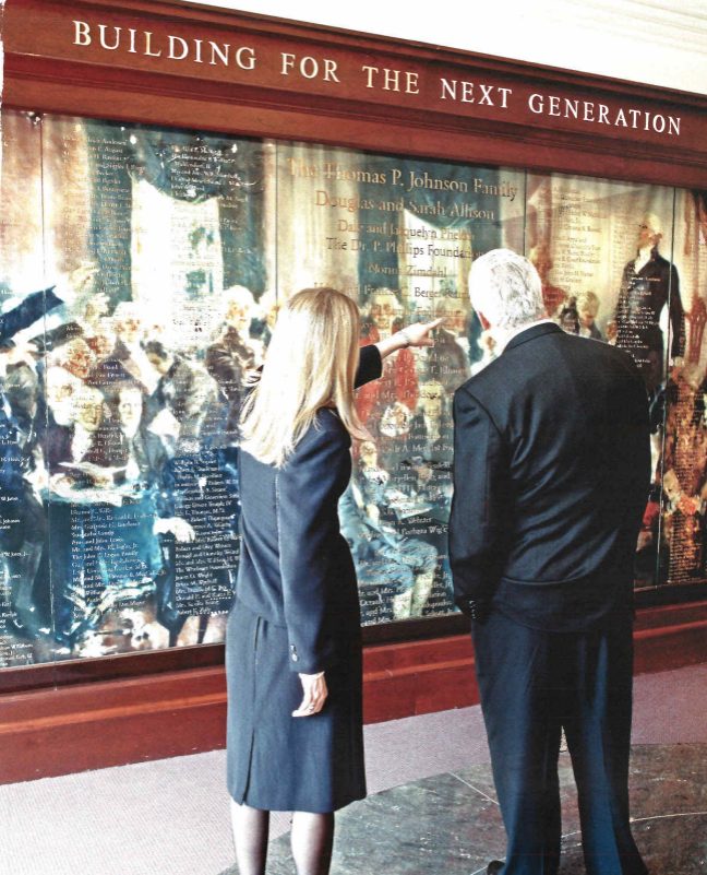 People in suits viewing new Heritage building lobby.