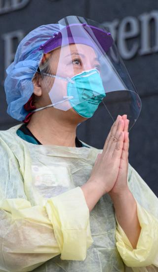 NYU Langone Health workers stand outside with a round of applause for medical staff and essential workers on the front lines of the coronavirus pandemic on April 6, 2020 in New York City.