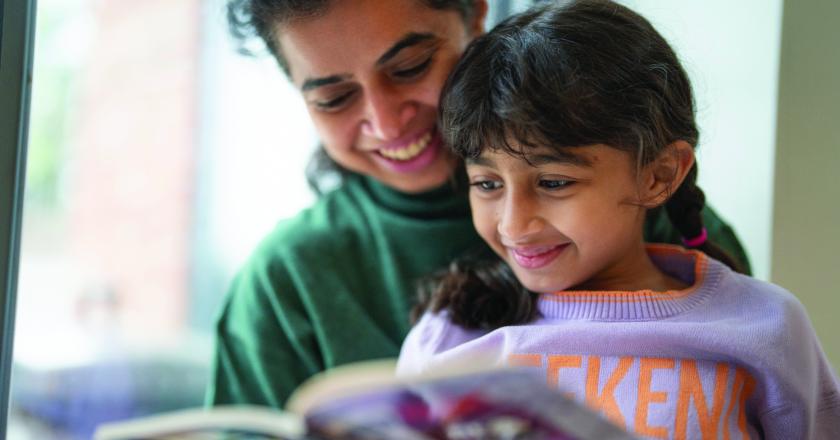 Women and her daughter reading a book