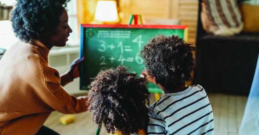 Teacher doing math with two students.
